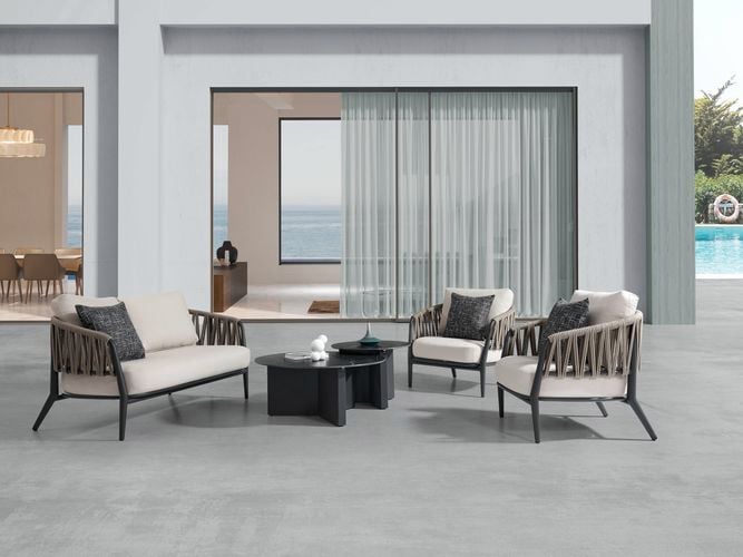 A rope outdoor lounge setting with two rope chairs, a sofa and a coffee table set