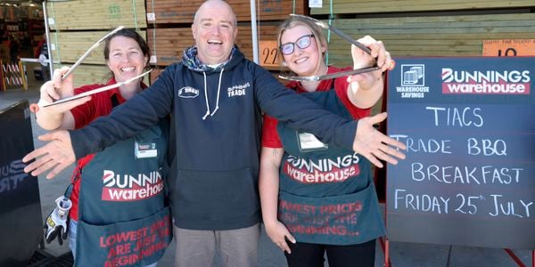 Two Bunnings team member with another person wearing a Bunnings x TIACS Trade hoodie