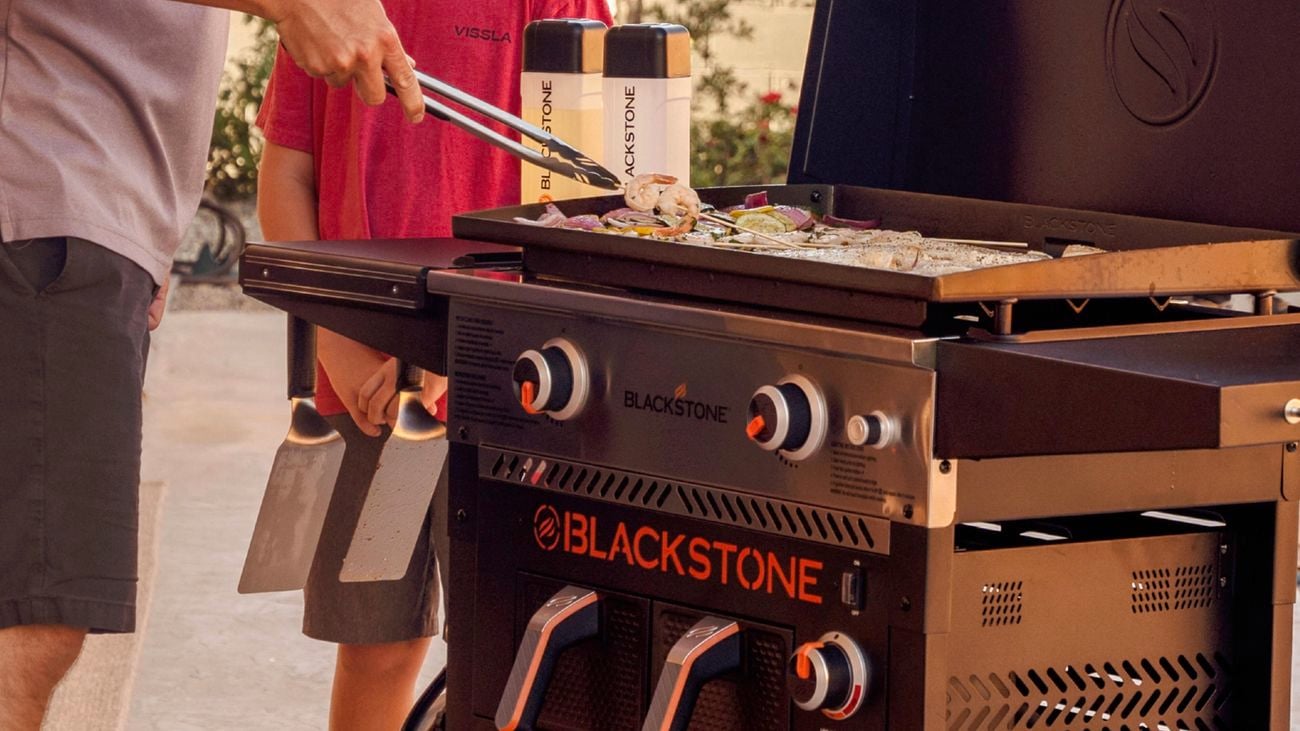 Father and son standing around Blackstone griddle cooking