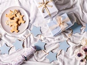 MDF light blue star garland with presents and gingerbread men on a tablecloth