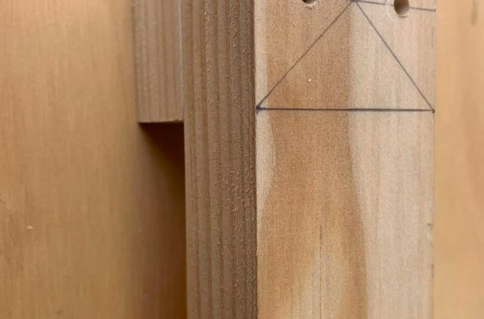 A length of timber marked and drilled for securing to another piece of timber below