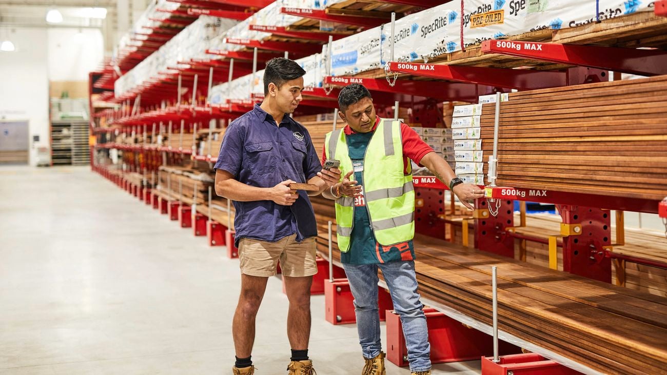 A Bunnings Warehouse team members shows a tradie how to use his PowerPass app in-store