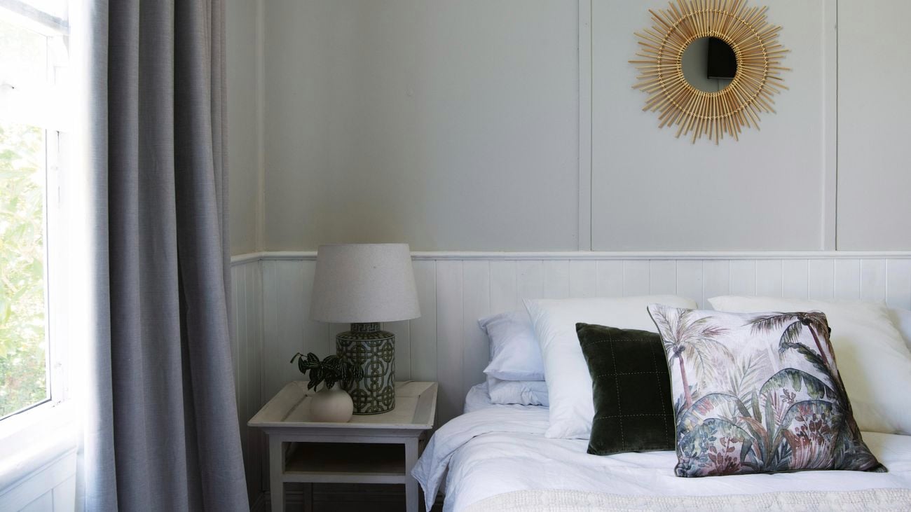 Bed and a bedside table with a lamp on it in a bedroom