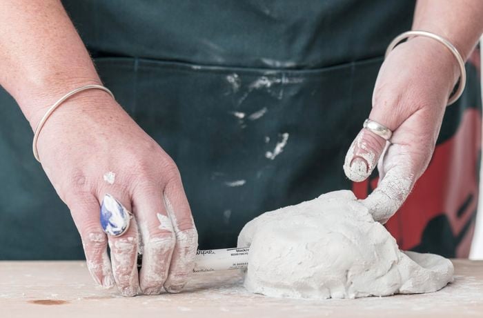 A charge cable hole being cut out of the back of a clay monster head