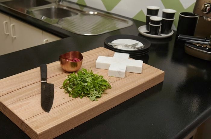 A wooden chopping board with knife and parsley