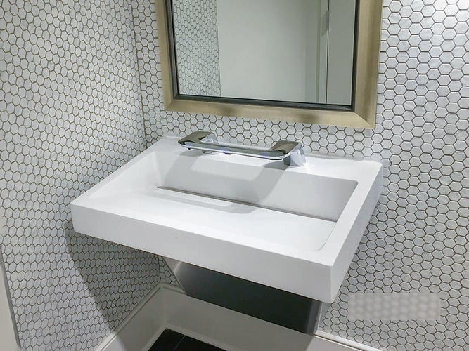 Bathroom with hexagonal tiles, large mirror and white sink