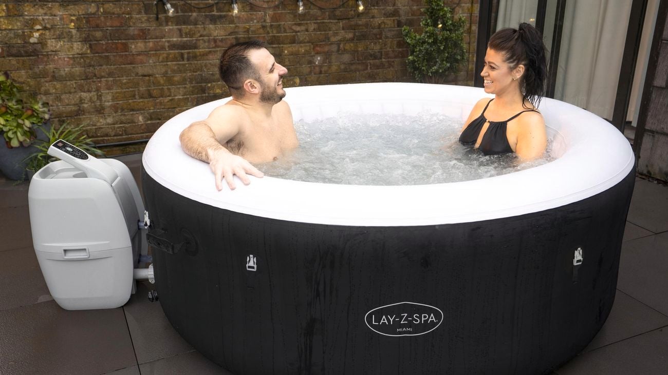 Man and a woman facing each other sitting in a Lay-Z-Spa