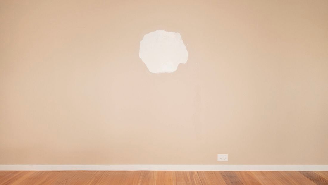 An image of a large hole in the plasterboard wall