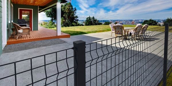 Wire grid black fence in the backyard of a house
