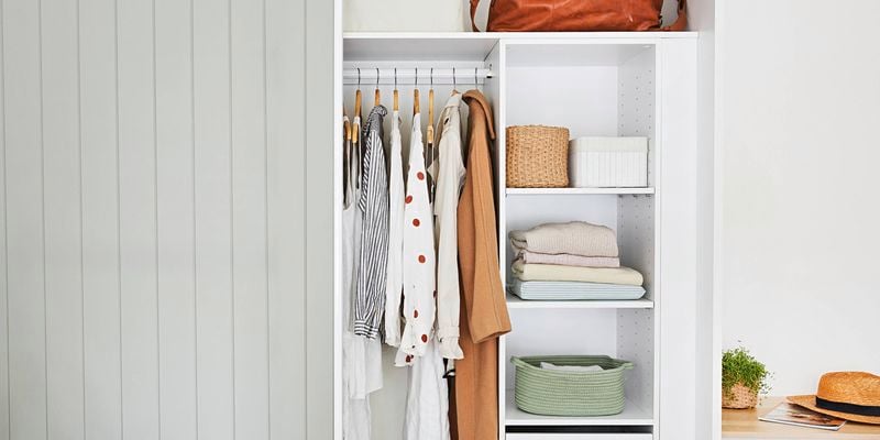A well-organised and decluttered wardrobe with storage and some hanging items.