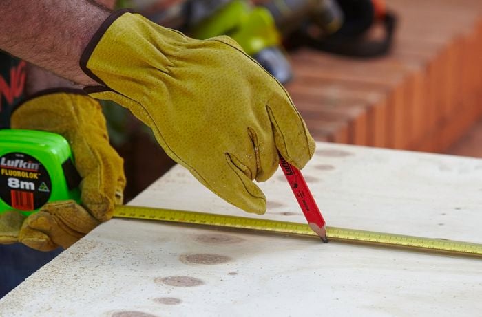 Using a pencil to mark the dimensions of the window frame