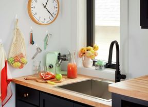 Utensils and bag hanging from a wall in a kitchen using hooks.