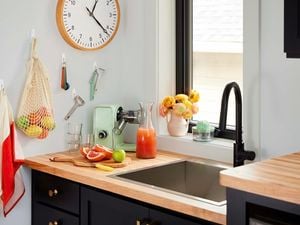 Utensils and bag hanging from a wall in a kitchen using hooks.