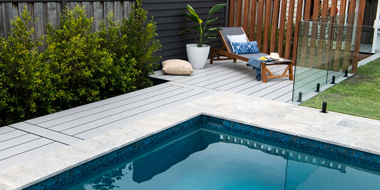 Pool surrounded by timber decking with a lounge chair