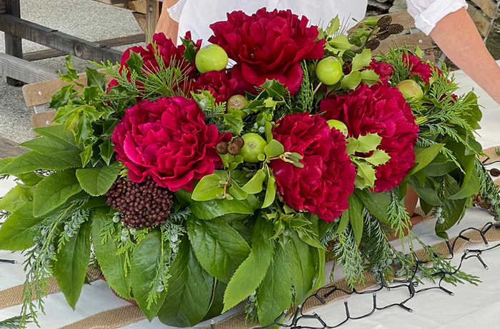 Festive tabletop setting with red flowers and green foliage