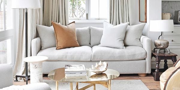 Living room with grey interior theme, a patterned grey rug with couch on top and two lamps beside the couch.