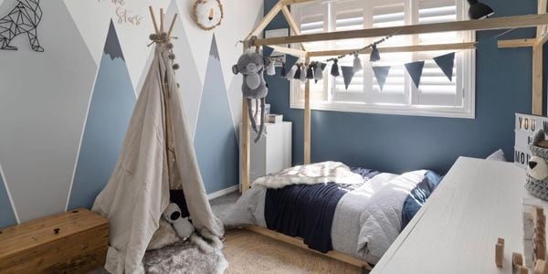 Kids bedroom with a bed play tent and mountain mural on the wall.