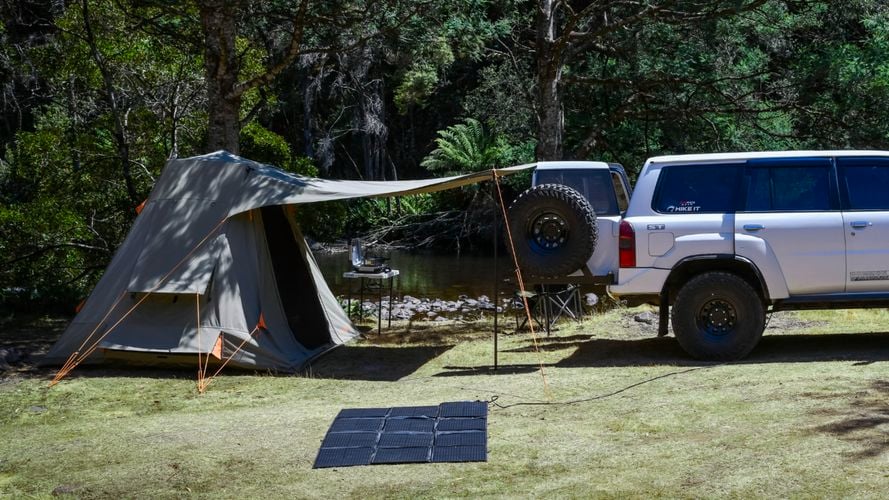 KT Solar 300W Solar Folding Blanket positioned in front of a campsite with a tent and 4WD vehicle.