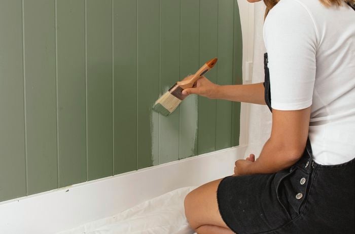 Person painting a wall.