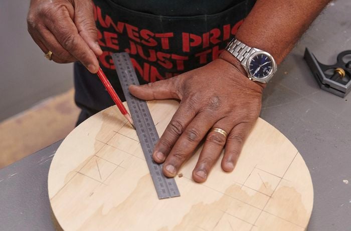 Positions for stool seat legs being marked with a ruler and pencil