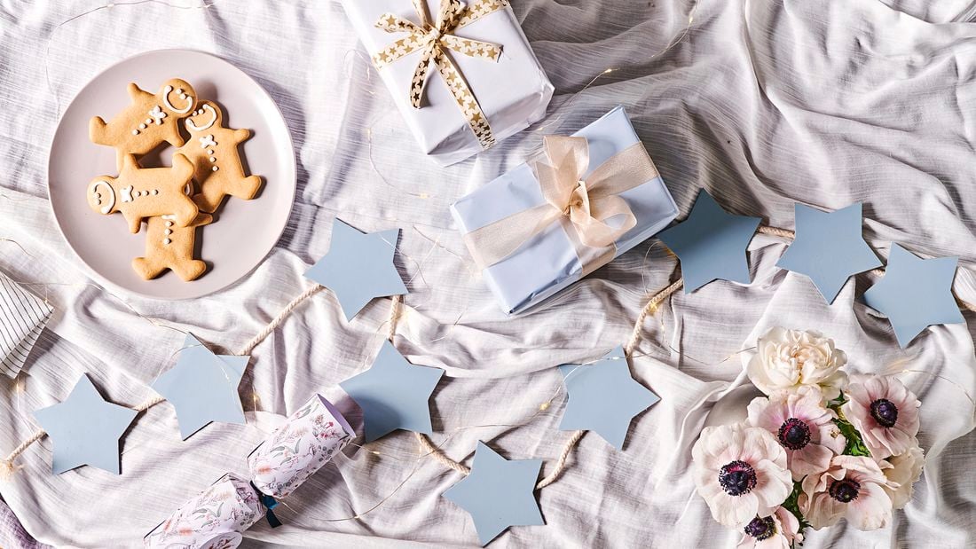 MDF light blue star garland with presents and gingerbread men on a tablecloth