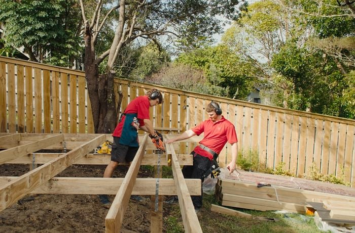 Two bunnings team member helping each other holding timber together