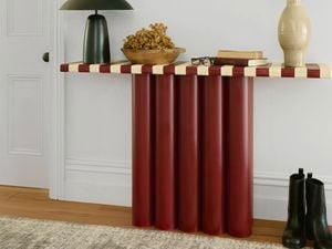 A completed hallway console table made from red cylindrical legs with a striped tabletop, styled with decor in a home interior.