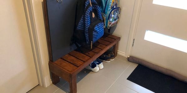 A storage shelf and schoolbag rack in a hallway