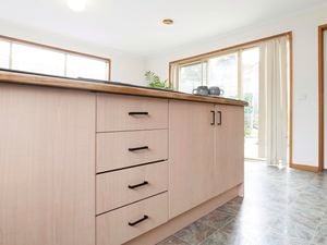 Kitchen bench with woodgrain cupboards and black handles