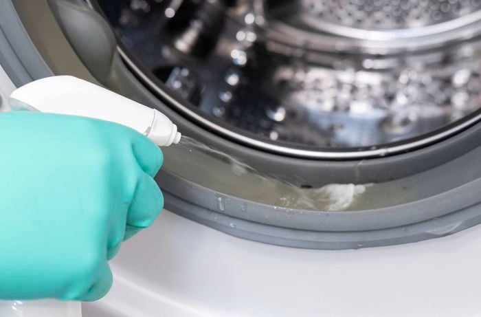 Applying mould cleaner to a front-loading washing machine door seal to help prevent mould