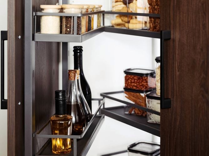 A pantry with the door open and shelving with items on it attached to the door.