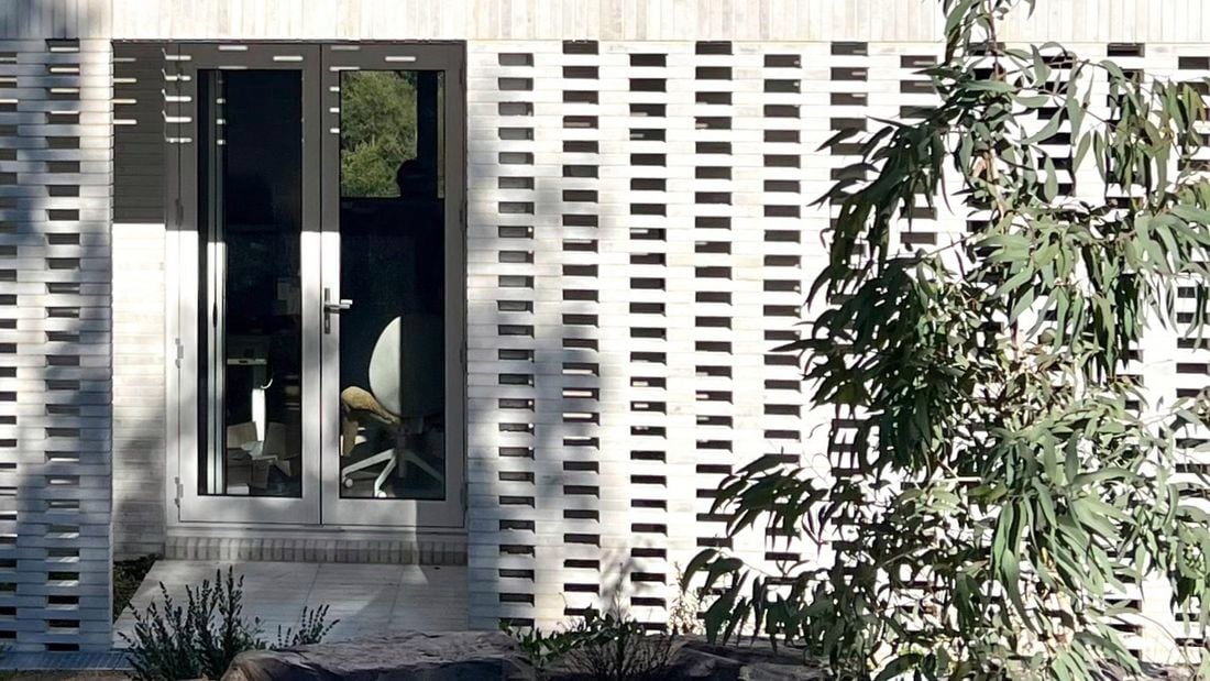 House with white brick exterior and glass panel door.