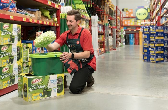 Man in Bunnings cleaning aisle holding Sabco Supadry Spin Mop.