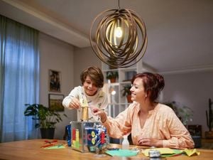 A lady and a young boy sitting at a round dining table, laughing