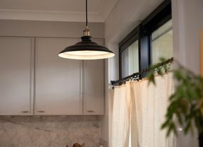 An elegant black and silver hanging light over a kitchen island.