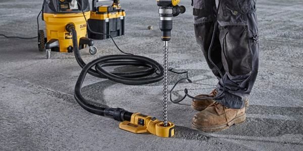 A construction worker drilling into the floor at a construction site