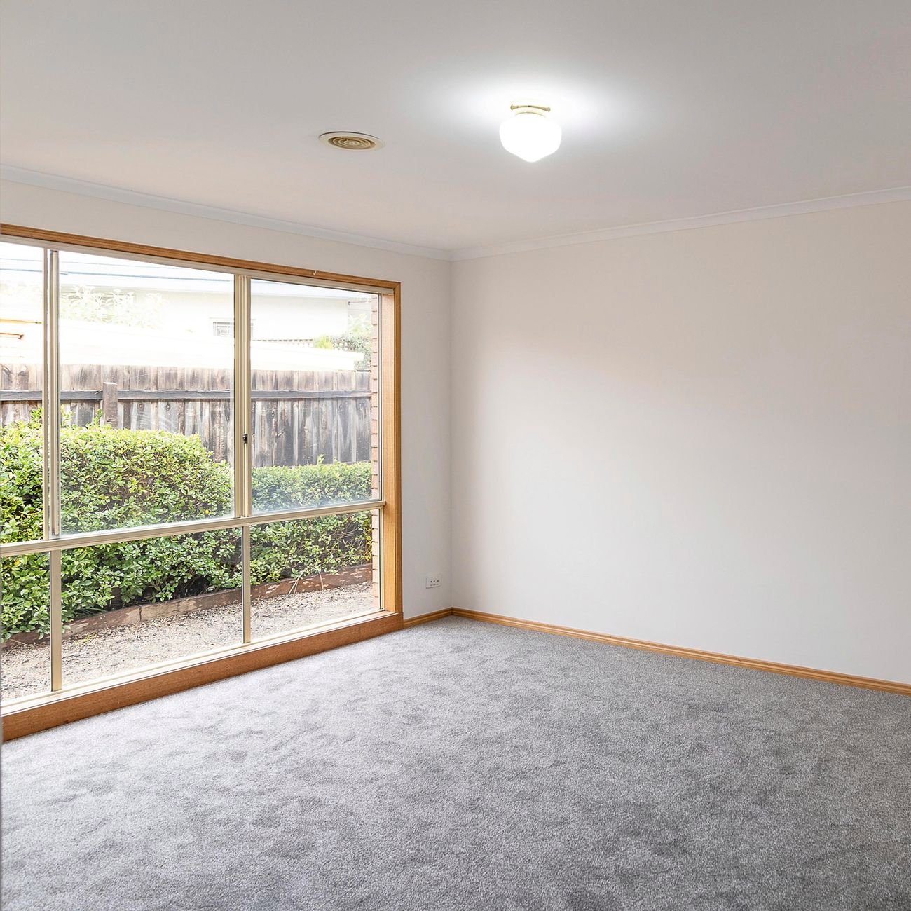 Empty room with cream walls and grey carpet.