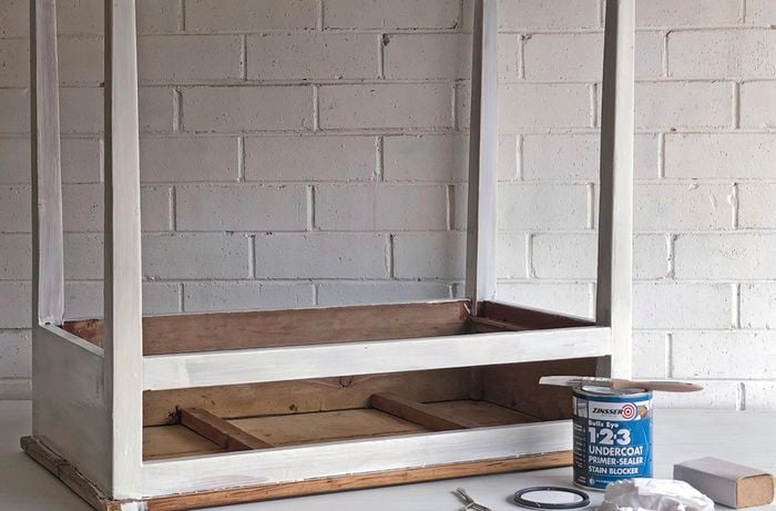Paint tin and brush next to an upside-down timber table painted white 