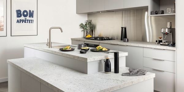 A mid shot of an urban edge style kitchen, with kitchen bench, cooktop, fridge and cupboards.
