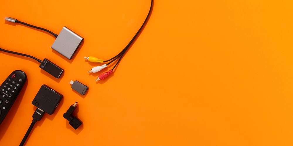 Orange background with various video accessories laid out on left side