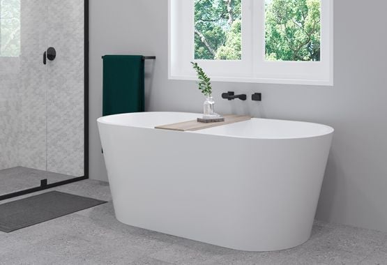 Large white bathtub with black tapware