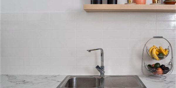 A kitchen with a white tiled splashback