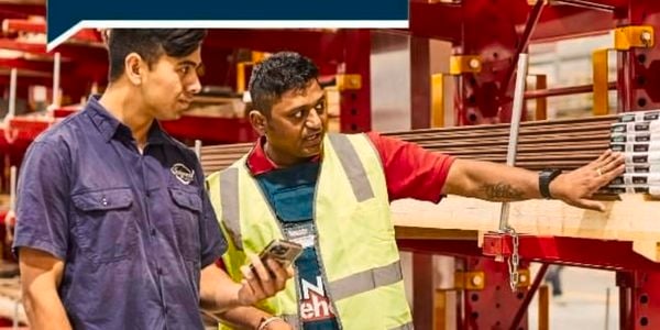 A Bunnings Team Member and customer standing in a timber yard at a Bunnings store.