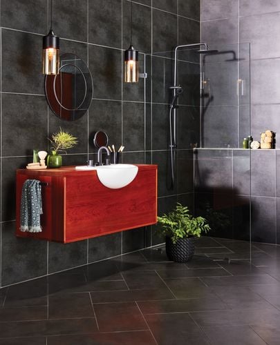Black tiled bathroom with shower and timber cabinet with built-in sink