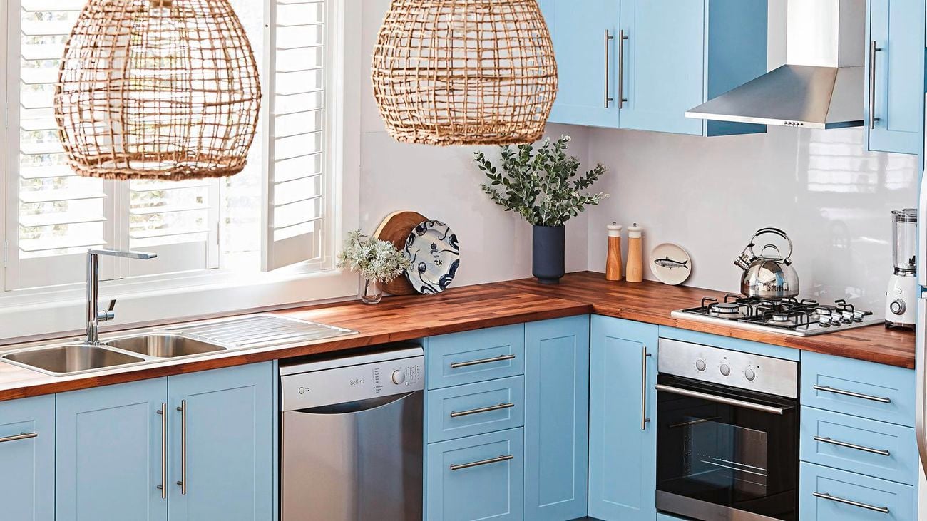 blue kitchen cabinetry, timber benchtop and rattan pendant lights