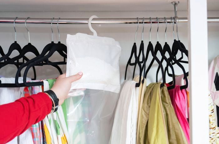 Placing a moisture absorber in a wardrobe to reduce humidity
