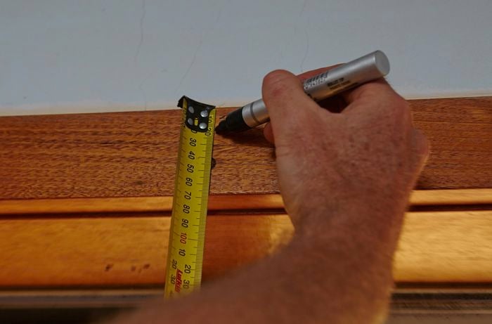 Person marking window frame with permanent marker.