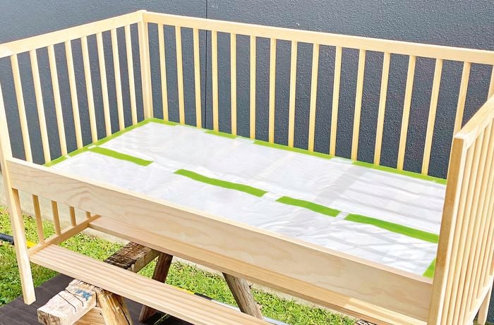Cot positioned on sawhorse, outdoors,  being left to dry