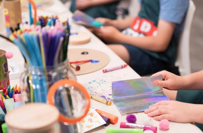 Kids are in a Bunnings DIY workshop with glossy paper.