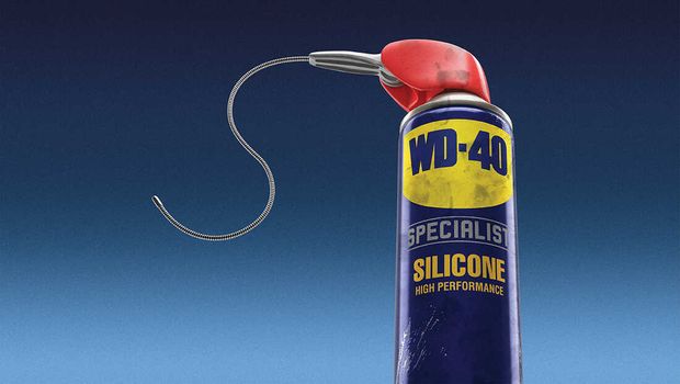 A bottle of WD-40 silicon spray can sitting in front of a navy blue background.
